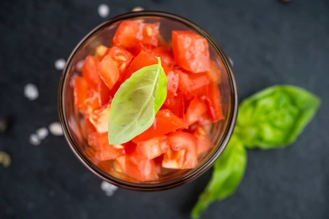 Portion of Cutted Tomatoes as detailed close up shot on a slate slab (selective focus)