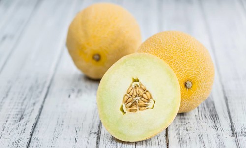 Honeydew Melon on an old wooden table as detailed close-up shot (selective focus)