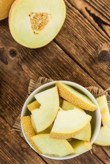 Honeydew Melon on an old wooden table as detailed close-up shot (selective focus)