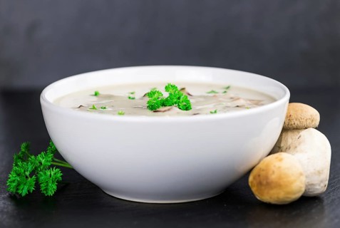 Some Porcini Soup on a slate slab as detailed close-up shot, selective focus