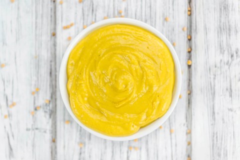 Mustard as high detailed close-up shot on a vintage wooden table (selective focus)