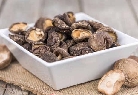 Fresh made Shiitake mushrooms (dried) on an old and rustic wooden table, selective focus, close-up