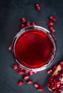 Pomegranate juice on a vintage background as detailed close-up shot (selective focus)