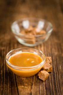 Caramel Sauce on a vintage background as detailed close-up shot (selective focus)
