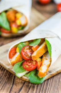 Chicken Wraps on a wooden table as detailed close-up shot (selective focus)