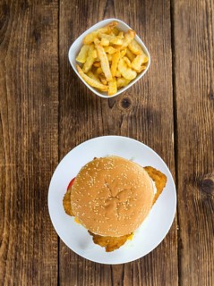 Fish Burger (selective focus, close-up shot) on wooden background