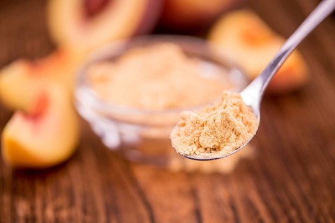Ground Peaches as high detailed close-up shot on a vintage wooden table, selective focus
