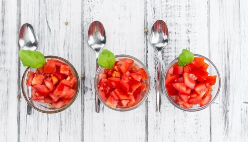 Homemade Diced Tomatoes on an wooden table (selective focus) as detailed close-up shot