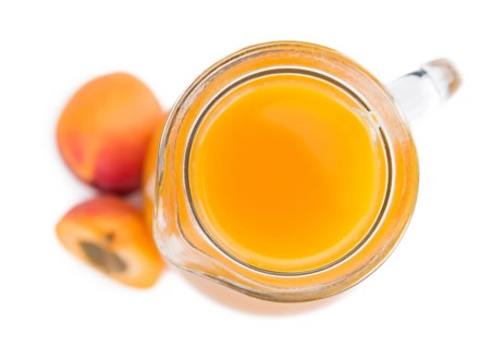 Fresh made Apricot Juice isolated on white background (close-up shot)
