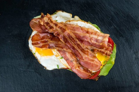 Slate slab with a Bacon and Egg Sandwich (close-up shot)