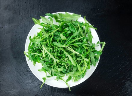 Slate slab with Arugula (detailed close-up shot, selective focus)