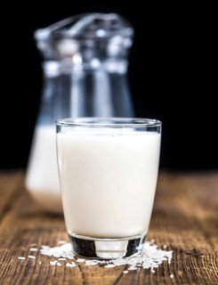 Wooden table with Rice Milk (detailed close-up shot, selective focus)