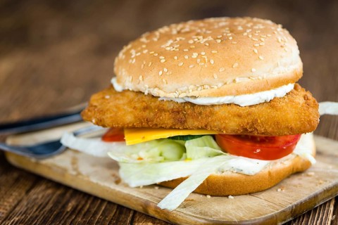 Fish Burger (selective focus, close-up shot) on wooden background