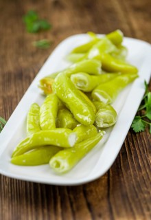 Fresh made Green Chilis (filled with cheese) on a vintage background (close-up shot)