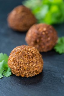 Portion of Falafel on an old wooden table (close-up shot, selective focus)