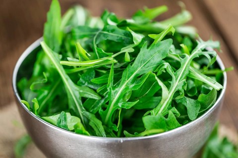 Fresh Arugula on an old wooden table as detailed close-up shot