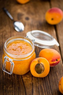 Apricot Jam on an old wooden table as detailed close-up shot (selective focus)