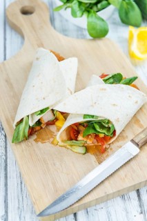 Chicken Wraps on a wooden table as detailed close-up shot (selective focus)