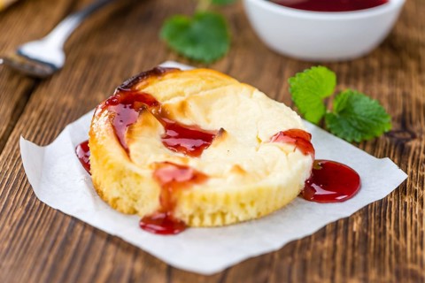 Fresh made Mini Cheesecake (with Sauce) on a vintage background (close-up shot)