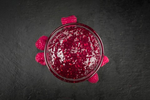 Fresh made Raspberry Jam on a vintage background as detailed close-up shot