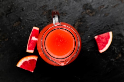 Portion of freshly squeezed Grapefruit Juice on a vintage background (selective focus, close-up