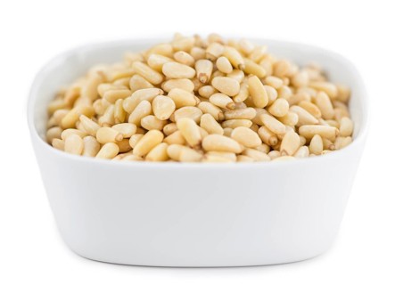 Portion of Pine Nuts (as close-up shot) isolated on white background