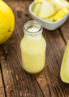 Honeydew Melon smoothie (close-up shot, selective focus) on a wooden table
