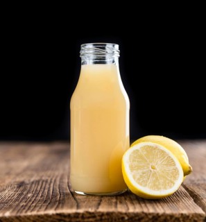 Homemade Lemon Juice on an wooden table (selective focus) as detailed close-up shot