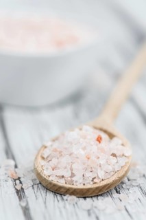 Salt (pink) on an old wooden table as detailed close-up shot (selective focus)