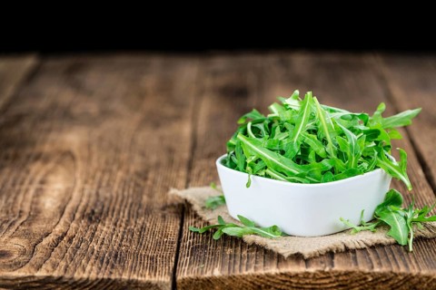 Fresh Arugula (selective focus) as detailed close-up shot on vintage background