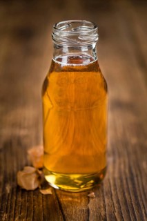 Syrup (Caramel taste) on an old wooden table as detailed close-up shot (selective focus)