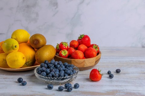 Harmonious still life of various fruits, strawberries, lemons, oranges, kiwis and blueberries on