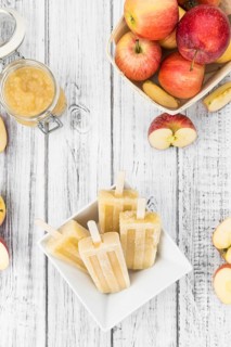 Vintage wooden table with Apple Popsicles (close-up shot, selective focus)