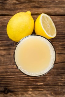 Homemade Lemon Juice on an wooden table (selective focus) as detailed close-up shot