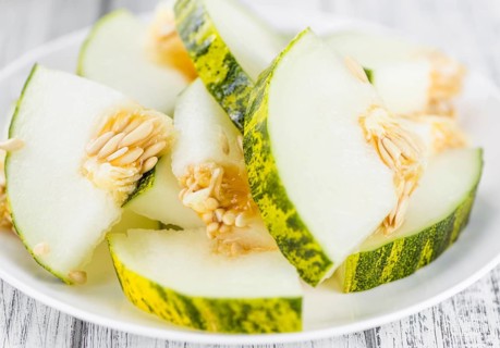 Fresh Futuro Melon as high detailed close-up shot on a vintage wooden table (selective focus)