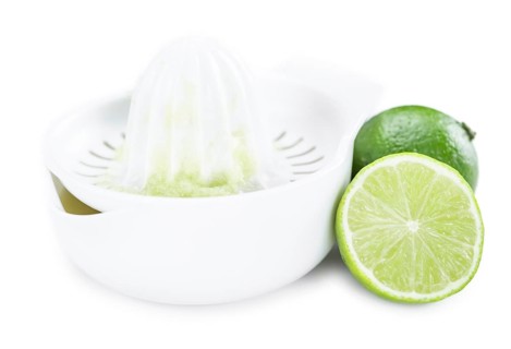 Portion of Lime Juice (as close-up shot) isolated on white background