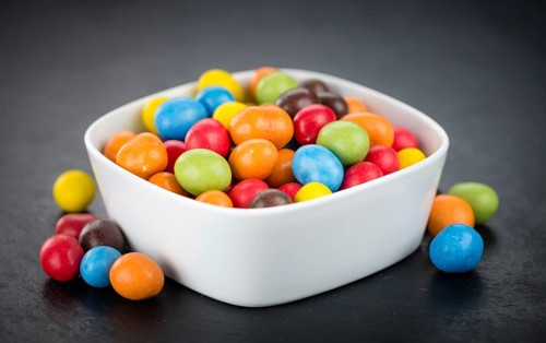 Portion of Cocolate coated Peanuts as detailed close up shot on a slate slab (selective focus)