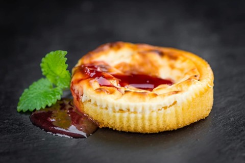 Cheesecake with Sauce on a vintage slate slab (close-up shot, selective focus)