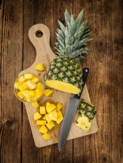 Sliced Pineapple on rustic wooden background as close-up shot