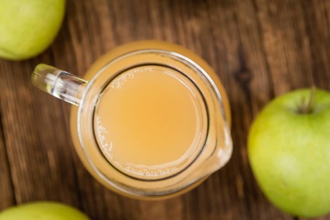 Apple Juice on an old wooden table as detailed close-up shot (selective focus)