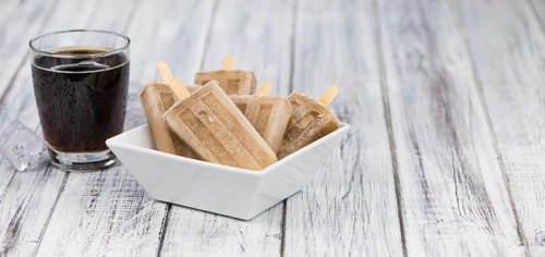 Fresh made Cola Popsicles on wooden background (selective focus, close-up shot)
