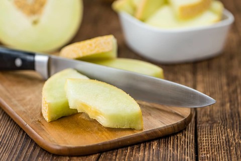 Honeydew Melon on an old wooden table as detailed close-up shot (selective focus)