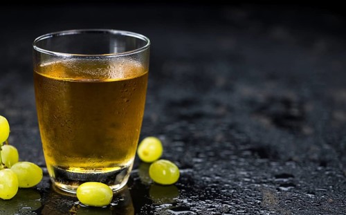 Some healthy Grape Juice on a vintage slate slab (selective focus)