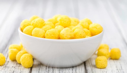 Cheese Balls on rustic wooden background (close-up shot)