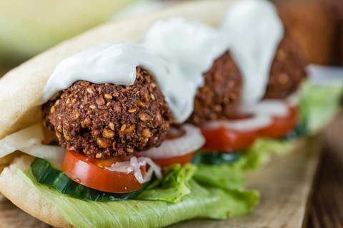 Fresh made Falafel Sandwich (close-up shot, selective focus) on an old wooden table