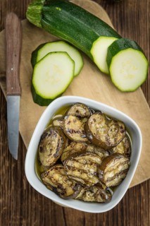 Fresh made Zucchinis (grilled) on an old and rustic wooden table (selective focus, close-up shot)