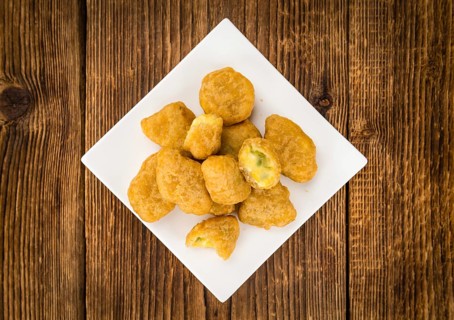 Portion of homemade Chili Cheese Nuggets on wooden background (selective focus, close-up shot)