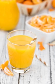 Portion of fresh made Tangerine Juice (close-up shot, selective focus)