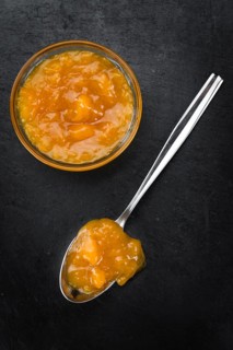 Portion of Apricot Jam on a rustic slate slab (selective focus, close-up shot)