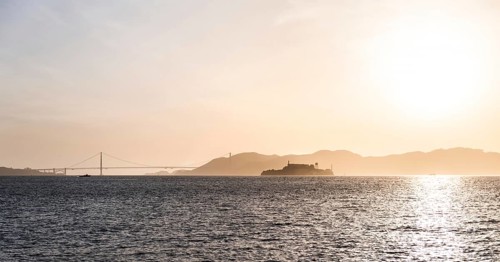 Alcatraz Island at sunset with Golden Gate Bridge in the Background